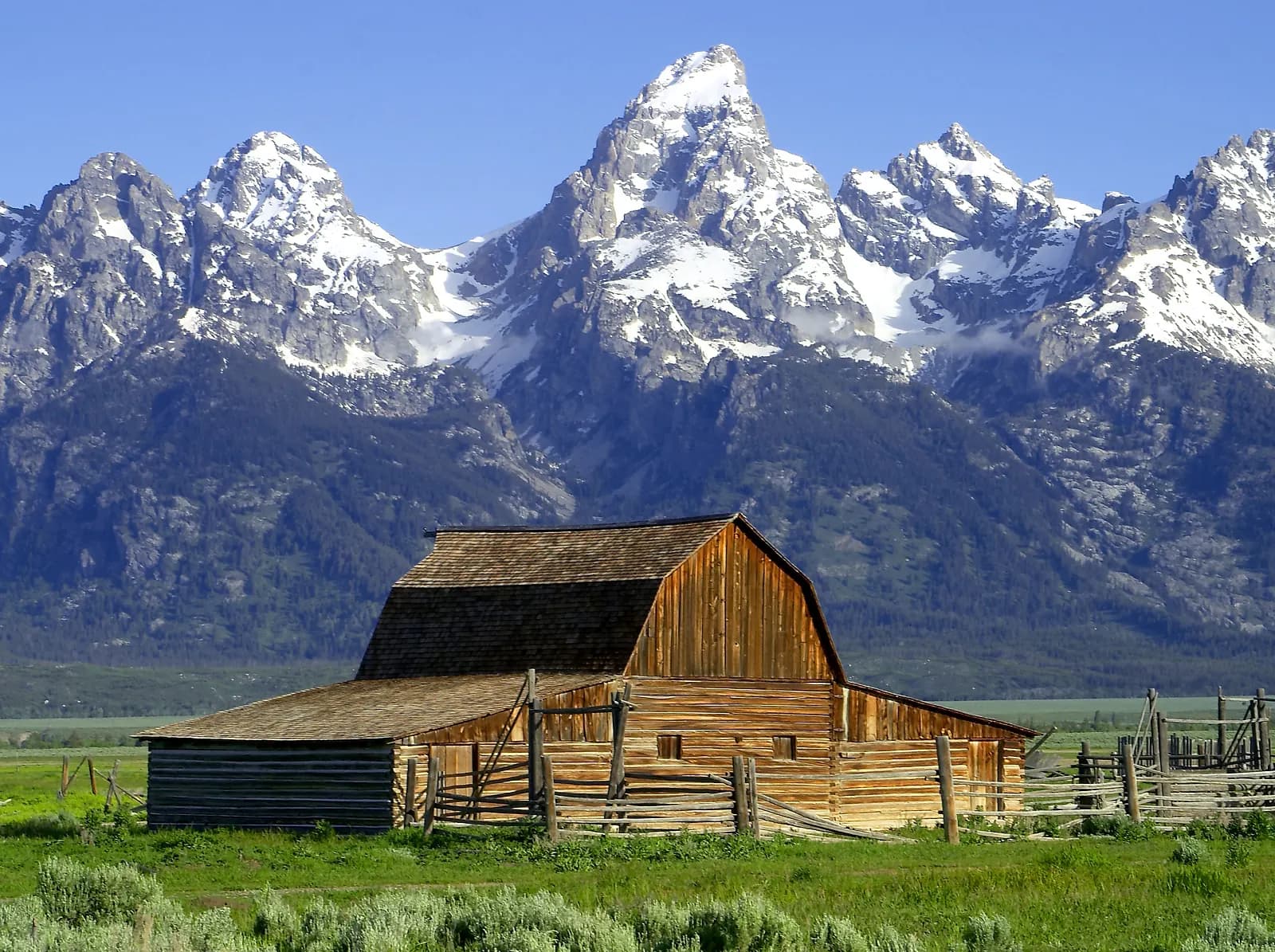 Weathered barns on the flats below the peaks of Grand Teton National Park